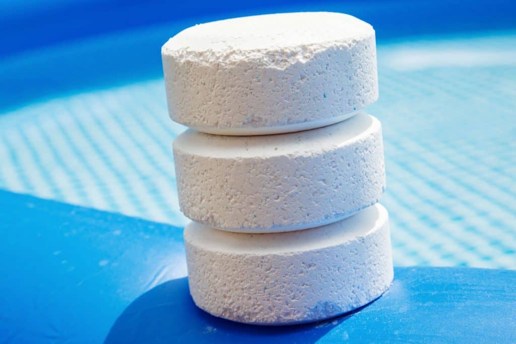 Chlorine pucks stacked up into a total of 3 on edge of pool.